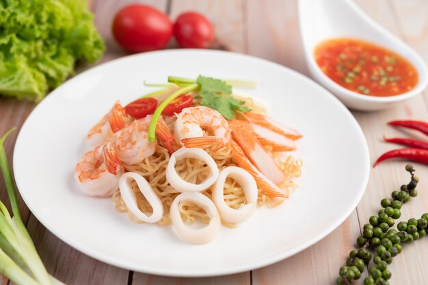 Nouilles instantanées sautées aux crevettes et au crabe dans un plat blanc.