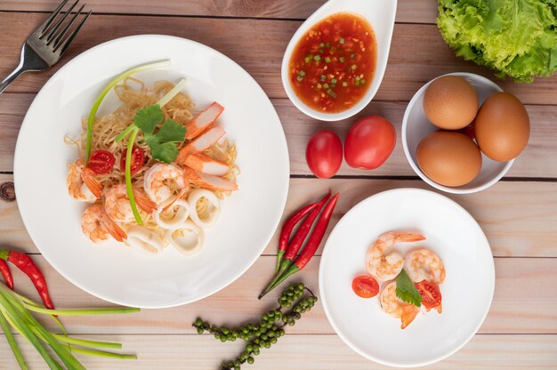 Nouilles instantanées sautées aux crevettes et au crabe dans un plat blanc.