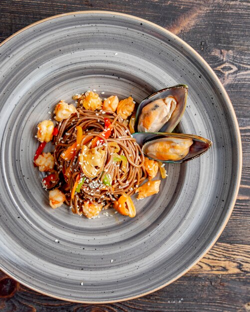 Nouilles préparées avec des poivrons de fruits de mer, graines de sésame et sauce