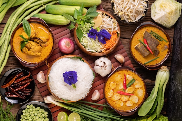 Nouilles de riz dans un bol de pâte de curry avec piment, concombre, haricot long, citron vert, ail et oignon nouveau