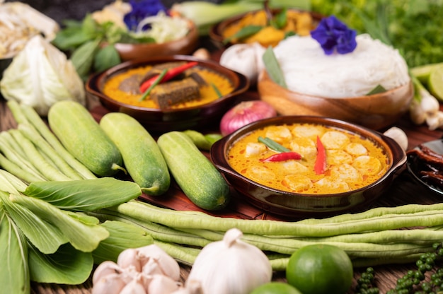 Photo gratuite nouilles de riz dans un bol de pâte de curry avec piment, concombre, haricot long, citron vert, ail et oignon nouveau