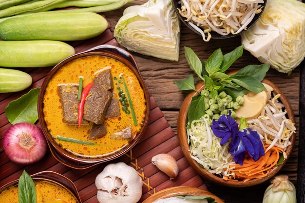 Nouilles de riz dans un bol de pâte de curry avec piment, concombre, haricot long, citron vert, ail et oignon nouveau