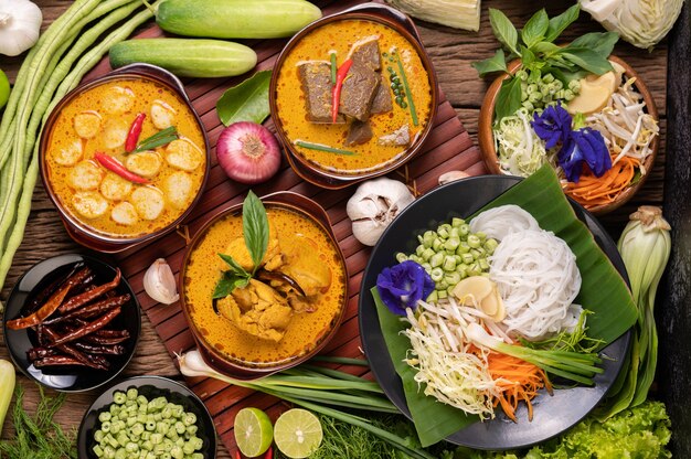 Nouilles de riz dans un bol de pâte de curry avec piment, concombre, haricot long, citron vert, ail et oignon nouveau