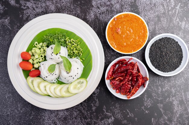 Nouilles De Riz Dans Une Feuille De Bananier Avec Des Légumes Et Des Accompagnements Joliment Dressés. Nourriture Thaï.