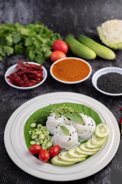 Nouilles de riz dans une feuille de bananier avec des légumes et des accompagnements joliment dressés. Nourriture thaï.