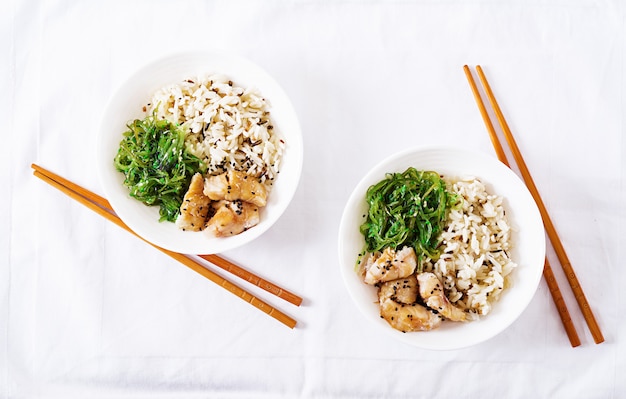 Nourriture japonaise. Bol de riz, poisson blanc bouilli et salade de wakame chuka ou d'algues. Vue de dessus. Mise à plat