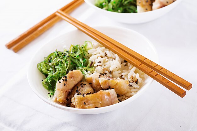 Nourriture japonaise. Bol de riz, poisson blanc bouilli et salade de wakame chuka ou d'algues.