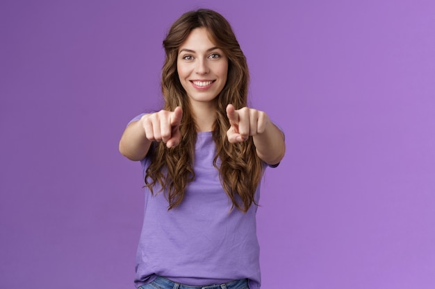 Nous avons besoin que vous rejoigniez notre équipe. Assertifed confiant beau directeur de bureau féminin hr recrutement de nouvelles personnes recherchant des débutants souriants sûrs d'eux pointant du doigt appareil photo fond violet