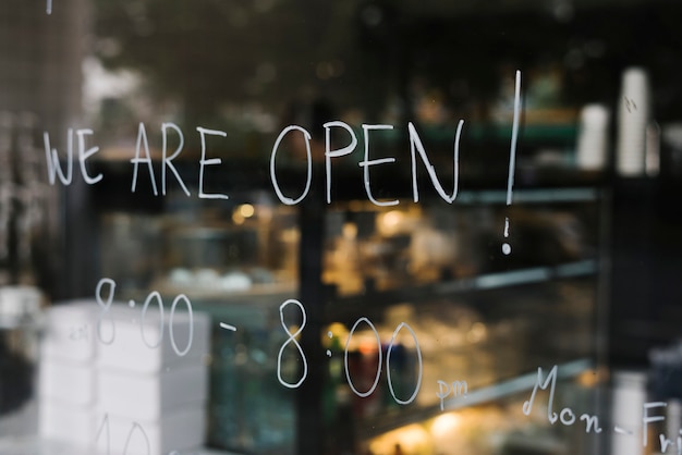 Photo gratuite nous sommes ouverts, sur le mur de verre d'un café