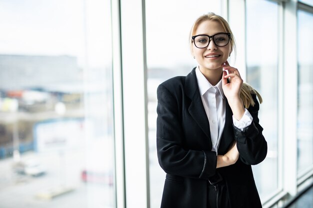 Nouveau jour, nouvelles décisions. Belle jeune femme tenant la main sur le menton et à la réflexion tout en étant assis sur son lieu de travail