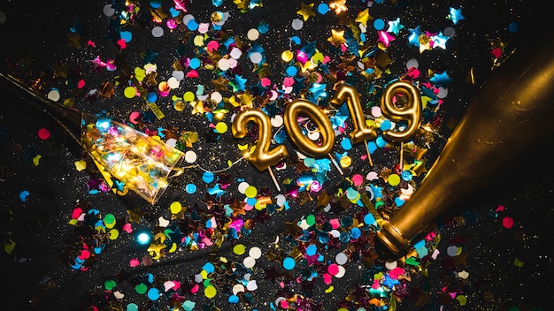 Nouvel an 2019 en forme de bougies sur une pile de confettis