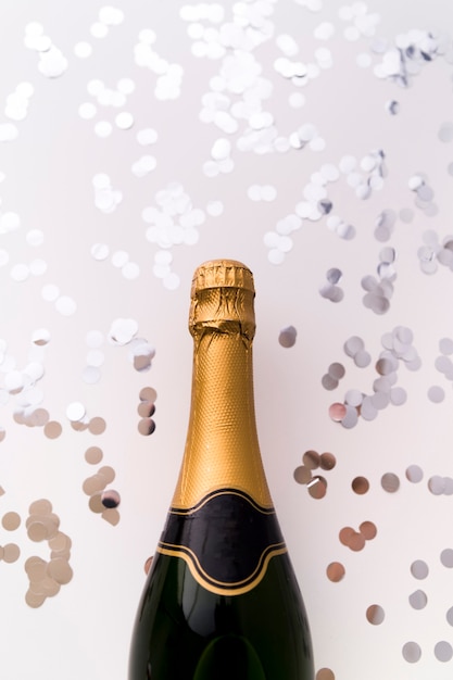 Nouvelle Bouteille De Champagne Et Confettis Argent Rond Sur Fond Blanc