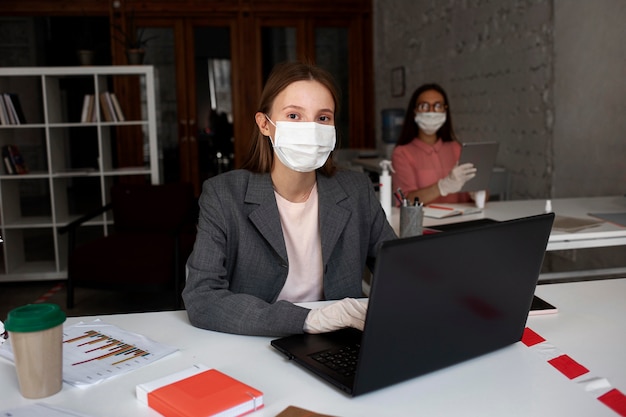 Photo gratuite nouvelle normale au bureau avec masque facial