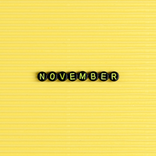 Photo gratuite novembre perles mot typographie sur jaune