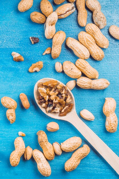 Noyer; cacahuètes et pistaches sur fond bleu texturé