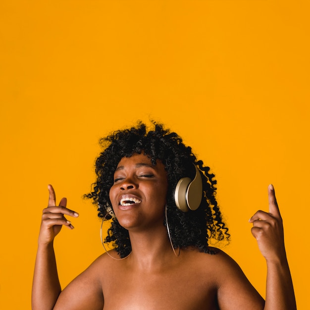 Nu jeune femme noire chantant dans le casque en studio
