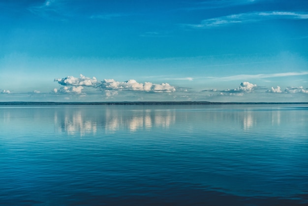 Photo gratuite nuages blancs purs du ciel reflétés dans l'eau de la mer