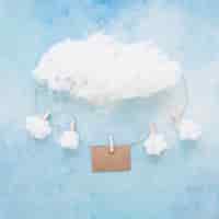 Photo gratuite nuages ​​et carte suspendus sur une chaîne avec des pinces à linge sur fond bleu