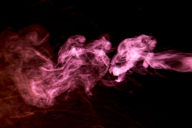 Nuages de fumée rose sur fond noir