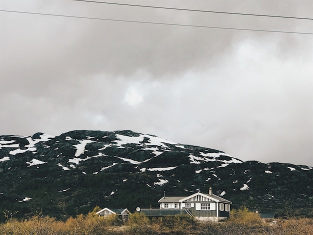 Photo gratuite des nuages ​​lourds pèsent sur les montagnes couvertes de neige