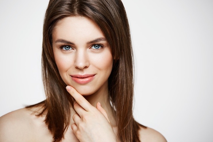 Photo gratuit nue jeune belle femme avec un maquillage naturel souriant. cosmétologie et spa. traitement facial.
