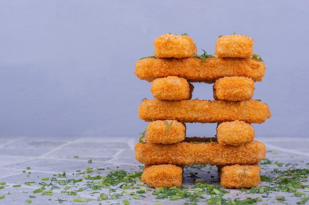 Nuggets de poulet frit avec garniture croustillante sur fond bleu.