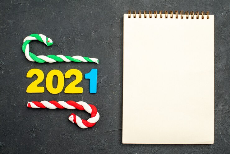 Photo gratuit numéro 2021 à côté du cahier vierge. nouvel an