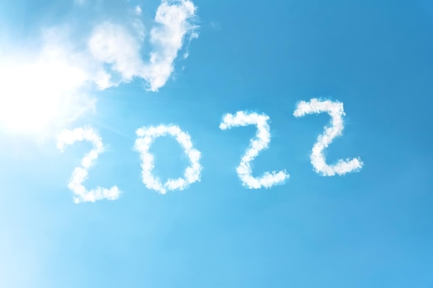 Numéros 2022 inscription symbole sur fond de ciel bleu de la fumée blanche des nuages éclairés par un soleil éclatant.