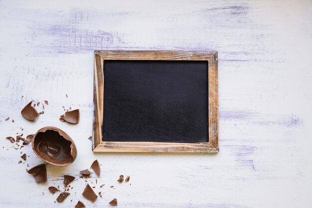 Photo gratuite oeuf au chocolat près du tableau noir