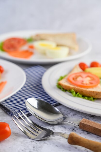 Un œuf au plat portant sur un toast, garni de graines de poivre avec des carottes, du petit maïs et des oignons de printemps.