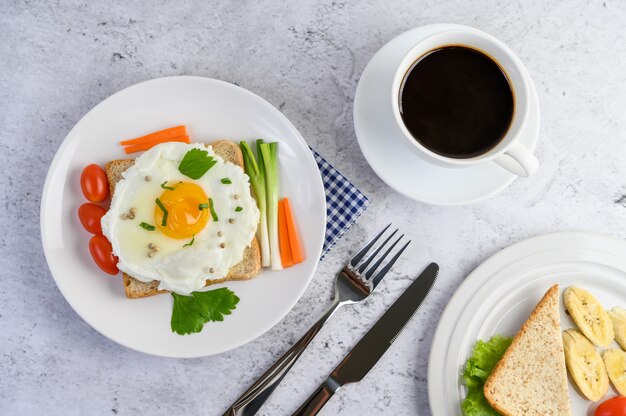 Un œuf au plat portant sur un toast, garni de graines de poivre avec des carottes et des oignons de printemps.