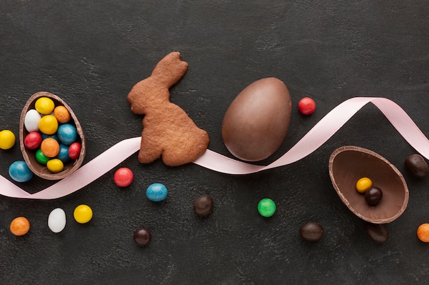 Oeuf en chocolat pour pâques et biscuits en forme de lapin avec des bonbons