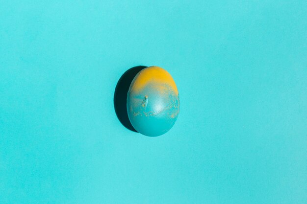 Oeuf de Pâques coloré sur la table bleue