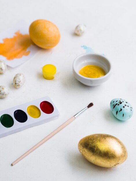 Oeuf de Pâques doré avec palette et pinceau