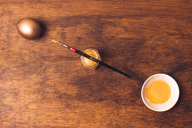 Oeuf de Pâques près d&#39;une soucoupe et pinceau sur une boîte de teinture