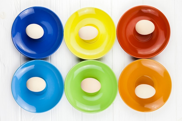 Oeufs sur des assiettes colorées