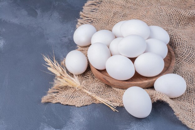 Oeufs blancs sur morceau de toile de jute.