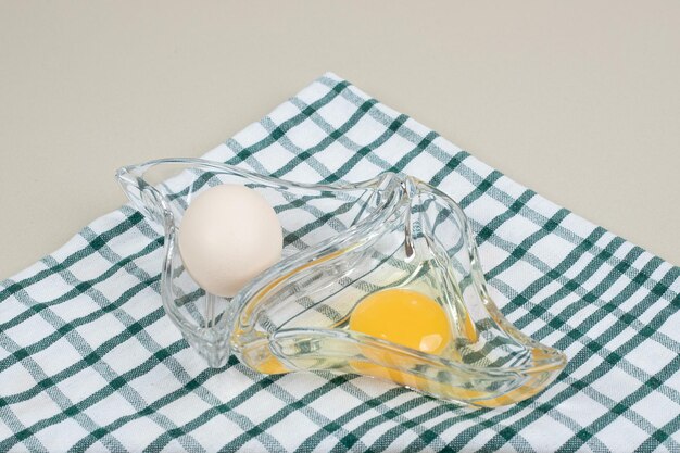 Oeufs blancs de poulet frais avec jaune sur plaque de verre.