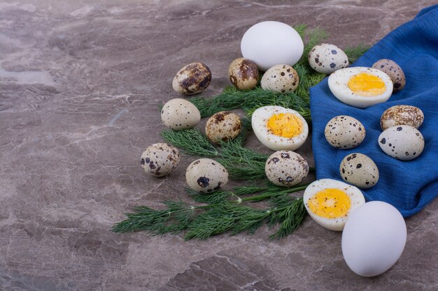 Oeufs Bouillis Et Crus Sur Morceau De Tissu Bleu.