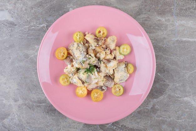 Oeufs brouillés aux légumes sur plaque rose.