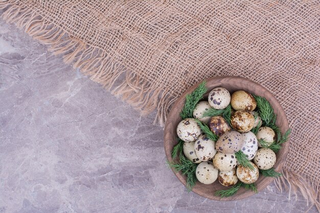 Oeufs de caille dans une tasse en bois avec des herbes