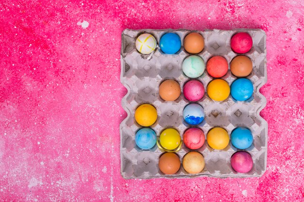 Oeufs colorés dans un plateau carré