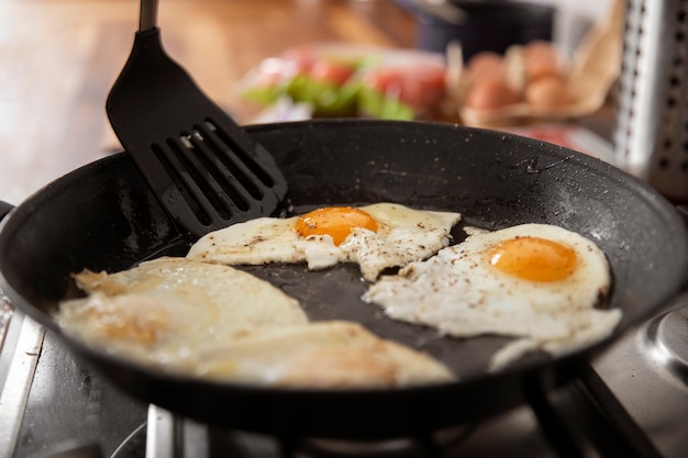 Photo gratuite oeufs délicieux à angle élevé dans la poêle