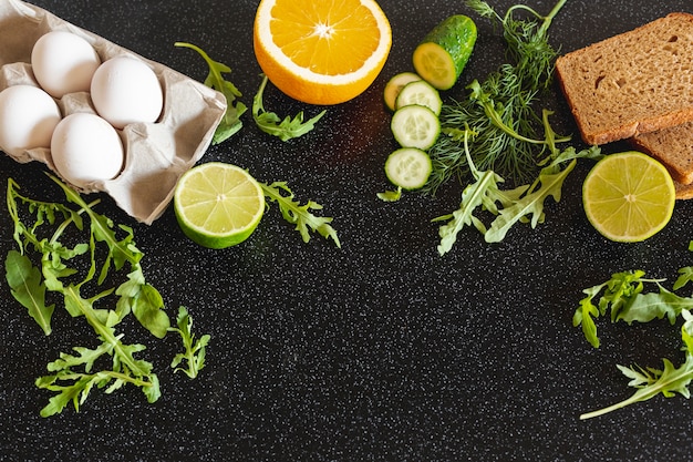 Oeufs avec des légumes et des mauvaises herbes sur un fond noir