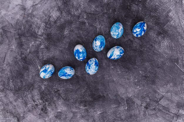 Oeufs de Pâques bleus dispersés sur une table grise