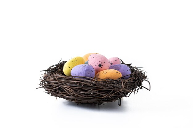 Oeufs de Pâques colorés à l'intérieur d'un nid isolé sur fond blanc