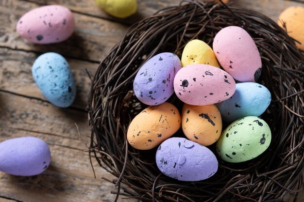 Oeufs de Pâques colorés à l'intérieur d'un nid sur une table en bois