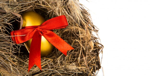 oeufs de Pâques dans le nid d&#39;or isolé sur fond blanc