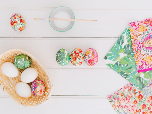 Oeufs de Pâques dans le panier près des serviettes de table et brosser le verre avec un colorant