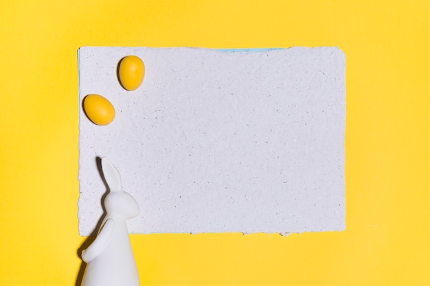 Oeufs De Pâques Sur Une Feuille De Papier Avec Un Lapin Sur Une Table Jaune